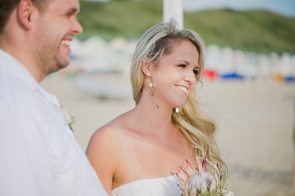 Photo Lachendes Brautpaar am Strand bei der Hochzeitszeremonie